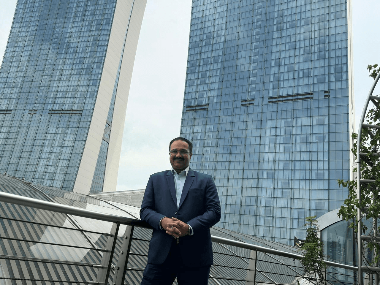 Sanjay Pan at Candeur Constructions with modern towers in the background