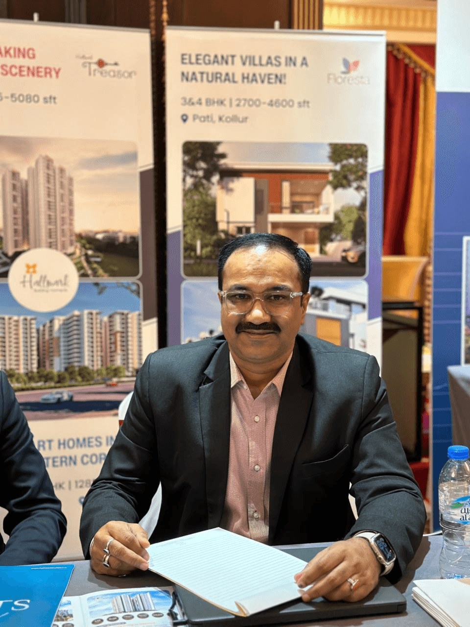 Sanjay Pan seated at a real estate exhibition desk