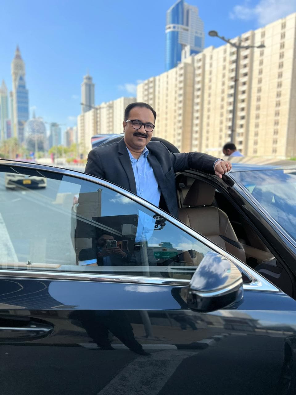 Sanjay Pan standing beside a car in an urban setting